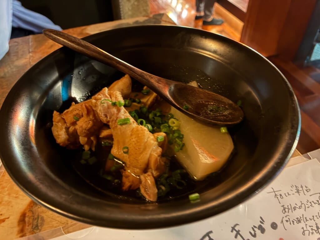 八十の別家のお通し(骨付き鶏と大根の煮込み)